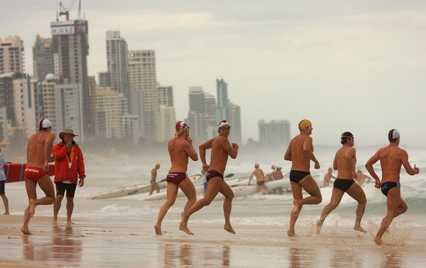 Daniel Moodie (facing camera) heads into the Kurrawa Beach surf during his ironman heat today.